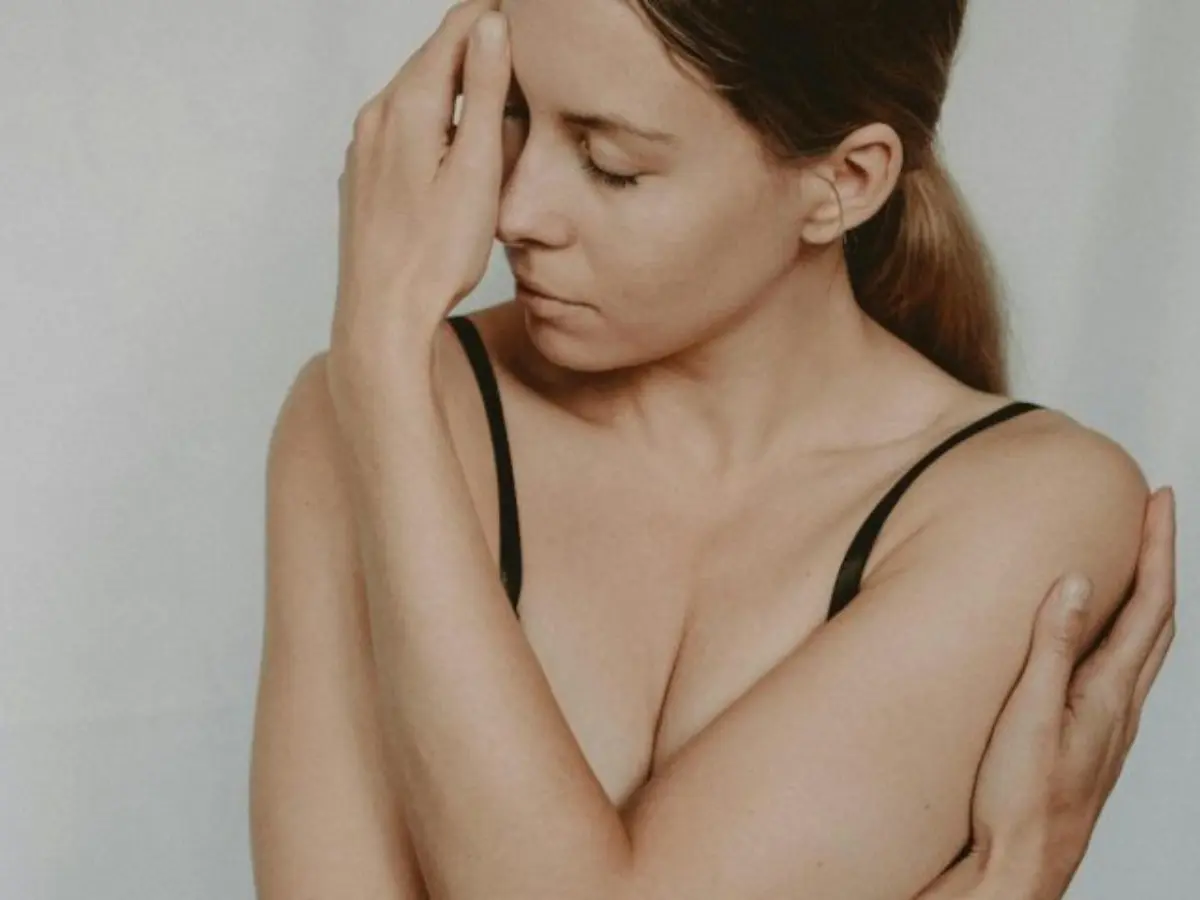 Žena zagrljenih ruku i zatvorenih očiju – lažna ljubav